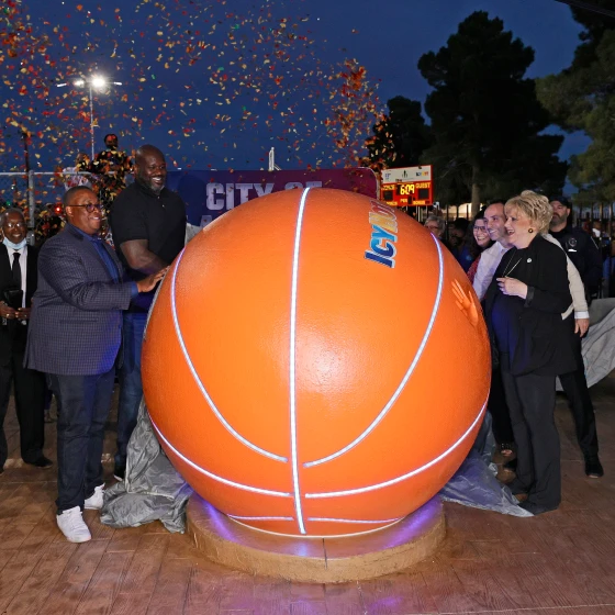 Shaquille O'Neil and other attendees at the inauguration of one of the Icy Hot Comebaq Courts. They are all standing next to a giant basket ball with the Icy Hot logo.